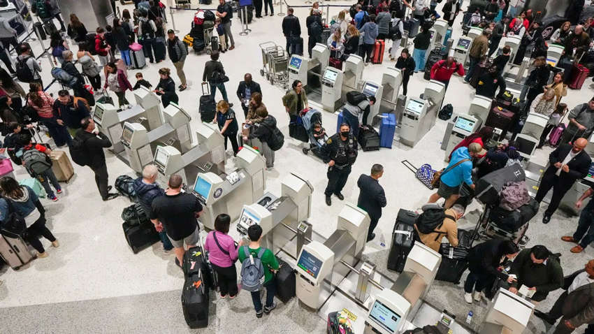 Passengers use check-in kiosks as they make their way through the C Terminal at George Bush Intercontinental Airport in Houston on December 21, 2023. While almost 3 million people a day were forecast to fly, there haven't been significant nationwide cancelations of US flights for this Christmas season. - Brett Coomer/Houston Chronicle/Hearst Newspapers/Getty Images
