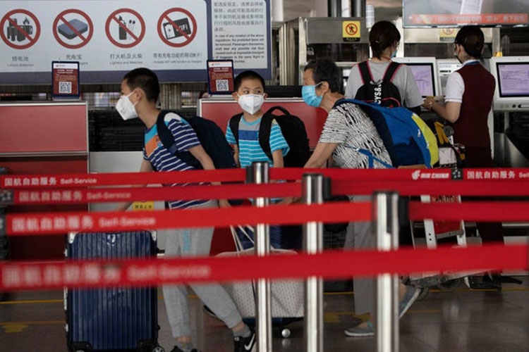 Passengers wearing masks to curb the spread of the coronavirus check in at the Beijing Capital Airport terminal 3 in Beijing on Wednesday, June 17, 2020. The Chinese capital on Wednesday canceled more than 60% of commercial flights and raised the alert level amid a new coronavirus outbreak, state-run media reported. Ng Han Guan, AP