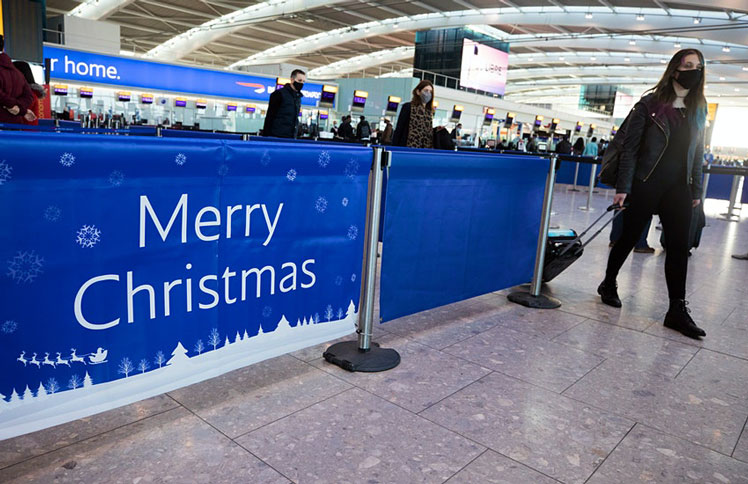 A passenger passes a 'Merry Christmas' sign in the check-in area in at London Heathrow Airport ©Getty Images
