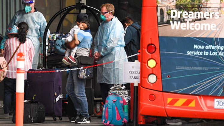 Travelers arrive at a hotel in Melbourne, Australia, to quarantine in December 2020. WILLIAM WEST/AFP/Getty Images